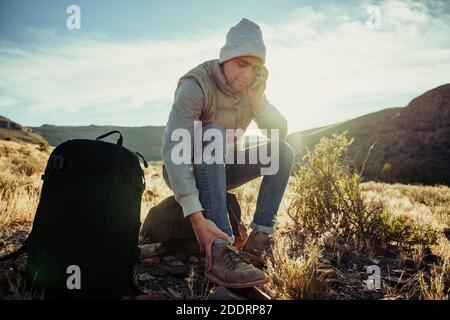 young man talking on cellphone walking through mountain on adventure hike  Stock Photo