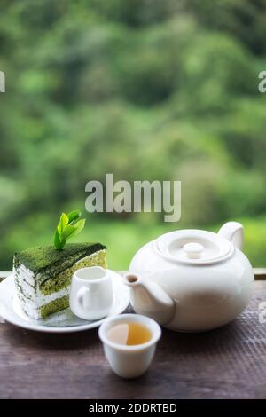 cup of tea on wooden table front of beautiful tea plantation and mountain in the morning time Stock Photo