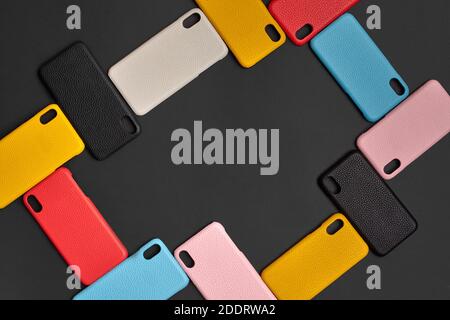 Set of colorful protective smartphone cases or covers on black studio background. Close up, copy space. Top view, flat lay, mock up Stock Photo