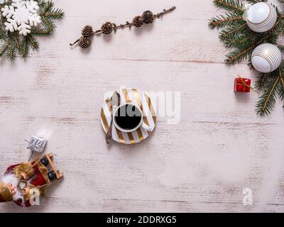 Christmas mug of coffee and Santa Claus on a sledge, top view, Christmas decorations, cupcakes and Christmas tree branches, free space Stock Photo