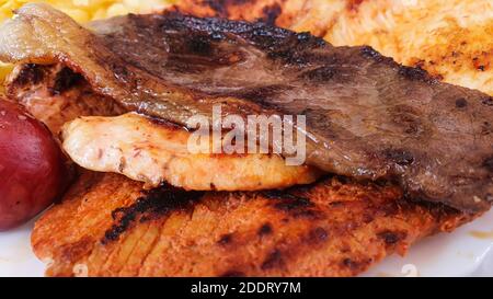 Close up of mixed grilled Steaks on a plate, with pork, beef, chicken and potato, selective focus Stock Photo