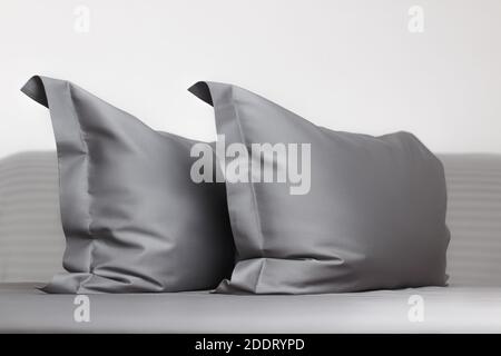 Two gray feather pillows on the bed. Stock Photo