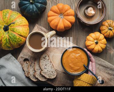 Pumpking sould with various little pumpkins on a rustic wooden table. Stock Photo
