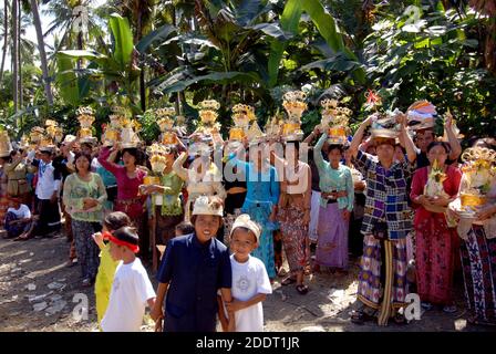 women wearing traditional dresses, carry offers for a funeral, in Bali, Indonesia. Stock Photo