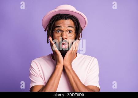Photo portrait of shocked man touching face with two hands isolated on vivid violet colored background Stock Photo