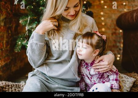 November 23, 2020. Anapa, Russia. Yong girl with mother in Christmas interior. Holiday winter time.