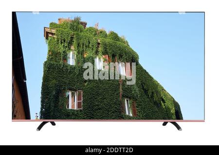 A modern TV with a resolution of 8K which shows the building is completely overgrown with vine lightly. TV set isolated on white background Stock Photo