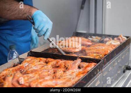 Chef cooking fresh red langoustine shrimps, prawns on grill at summer local food Stock Photo