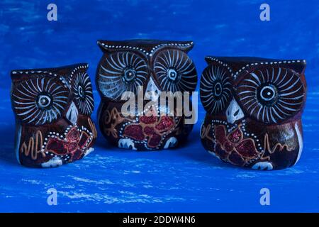 handmade artistic wooden carving statues show Three owls on watercolor background. family concept. Stock Photo