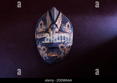 wooden colored african ethnic tribal mask on dark background Stock Photo