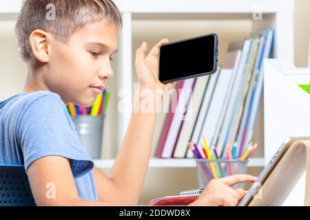 Teen boy distracting from online lesson and playing video games, scrolling  phone. Learning difficulties, online education, entertainment at home Stock  Photo - Alamy