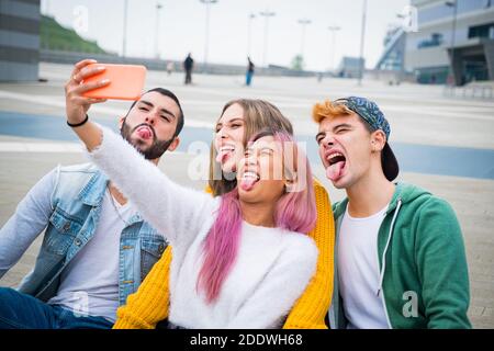 Group of teneegers making  faces and joking together while a video call with their friends - Group of friends on vacation taking a selfie to remember Stock Photo