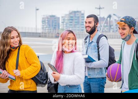 Education, healthcare and pandemic concept - Group of universitary students wearing face protective medical masks for protection from virus disease Stock Photo
