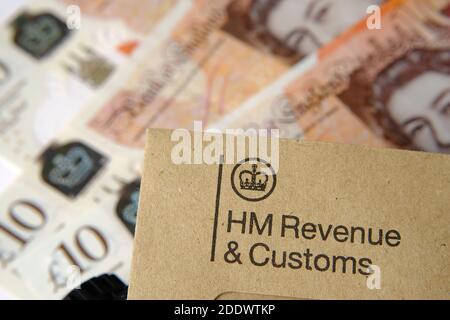 HM Revenue and Customs  (HMRC) letter seen with logos with the brown envelope and blurred money on the back. Stock Photo
