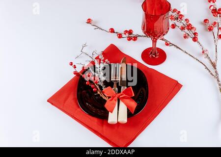 Christmas table dinnerware setting with red berry decorations on white background. Stock Photo