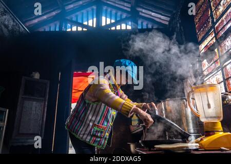 (201127) -- KUNMING, Nov. 27, 2020 (Xinhua) -- Dulong resident Dang Na makes pancakes in Kongdang Village of Dulongjiang Township, Gongshan Dulong and Nu Autonomous County, southwest China's Yunnan Province, Nov. 1, 2020. Dulong is a mountain-dwelling ethnic group in southwest China. It is one of the least populous of China's 56 minority nationalities. It is also called a 'direct-transition' minority ethnic group because the Dulong people didn't bid farewell to primitive life until the founding of the People's Republic of China in 1949 and since then they directly stepped into the socialist s Stock Photo