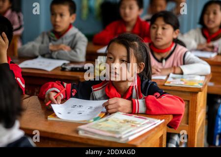 (201127) -- KUNMING, Nov. 27, 2020 (Xinhua) -- Dulong student Xiao Qinping attends a lesson at Dulongjiang Nine-Year Comprehensive School in Dulongjiang Township of Gongshan Dulong and Nu Autonomous County, southwest China's Yunnan Province, Oct. 31, 2020. Dulong is a mountain-dwelling ethnic group in southwest China. It is one of the least populous of China's 56 minority nationalities. It is also called a 'direct-transition' minority ethnic group because the Dulong people didn't bid farewell to primitive life until the founding of the People's Republic of China in 1949 and since then they di Stock Photo