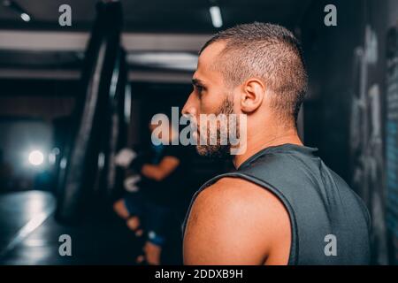 Photo - young handsome strong avtive man exercising in the gym, guy leads active healthy lifestyle, close up side view photo. challenge concept Stock Photo