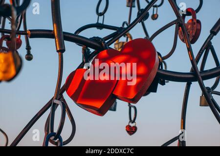 Close-up of the castle on the metal tree of the newlyweds in love in the form of two hearts, as a symbol of eternal love. Valentine's day concept. Stock Photo