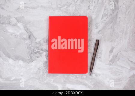 Red Notebook on on Gray marble. business, office supplies or education concept flat lay Stock Photo