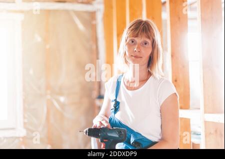 Portrait of a woman on a construction site with a tool.  Stock Photo