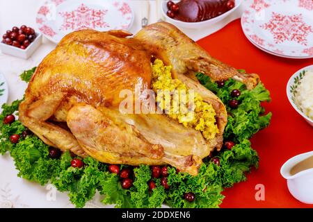 Christmas dinner table served with turkey, decorated with kale and cranberry. Holiday New Year concept. Stock Photo