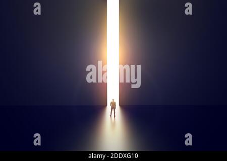 Businessman walking towards bright opening in concrete wall. Opportunity and success concept. Stock Photo