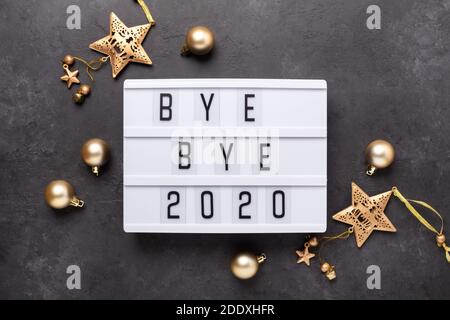 Lightbox with text BYE BYE 2020 with gold decoration on dark background. Top view. New year celebration. Happy New Year 2021 concepts - Image Stock Photo