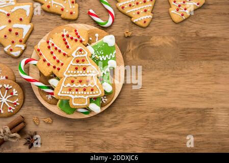 Assorted decorated Christmas gingerbread cookies on wood background, top view border design with copy space Stock Photo