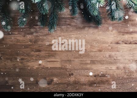 Green pine leaves and snow on wood table,top view  border design Christmas background with copy space Stock Photo