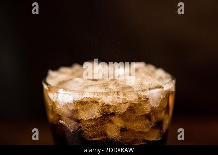 Close up of cold sparking cola sodar soft drink in the glass with foam bubble on top Stock Photo