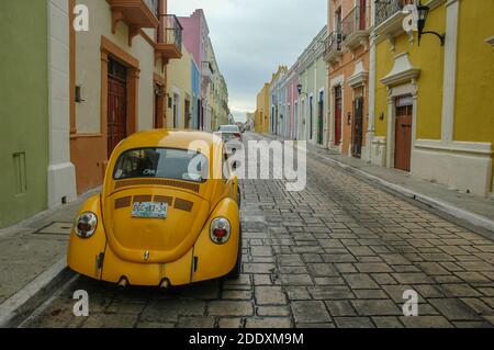 A yellow volkswagen beetle car parked on the old historic streets of Merida, Mexico. Stock Photo
