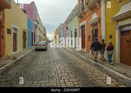 A historic street in Merida, Mexico in the Yucatan Peninsula. The historic buildings are pastel colors and in a colonial architecture style. Stock Photo