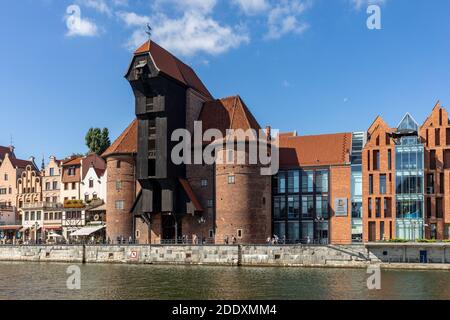 Gdansk, Poland - Sept 9, 2020: The largest medieval port Crane in Europe and historic buildings on the Dlugie Pobrzeze over the Motlawa River in Gdans Stock Photo