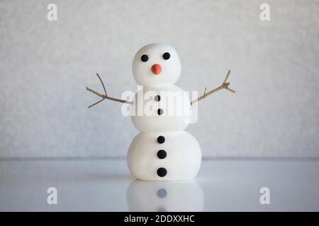 Cute snowman figure on winter frozen background. Mockup, artificial scene, greeting card, seasonal background. Stock Photo
