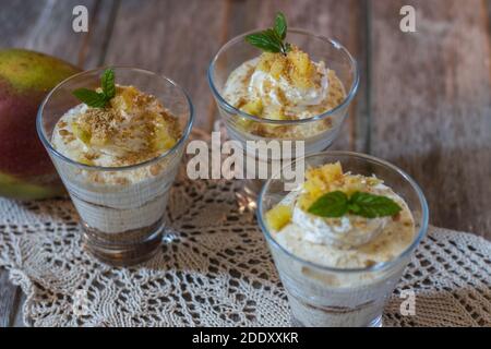 Mango mousse in glass cup with mint on wooden background Stock Photo