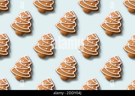 Seamless pattern of decorative cookies in shape of Christmas tree on blue background. Xmas holiday abstract background. Stock Photo