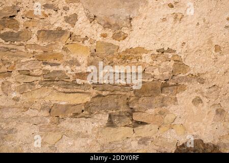 Background of old vintage stone wall with peeling plaster. Stock Photo