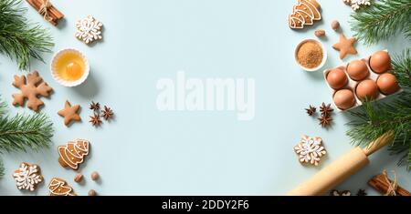 Christmas banner with cookies, different spices, eggs, rolling pin and ingredients for cooking on light blue background. Copy space. View from above. Stock Photo