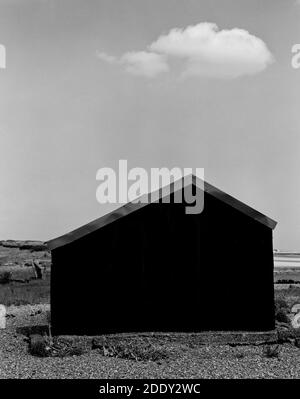 Cloud Hovers Over Tin Beach hut Stock Photo