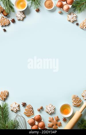 Christmas vertical cooking banner with traditional cookies with ingredients on light blue background. Space for text. View from above. Stock Photo