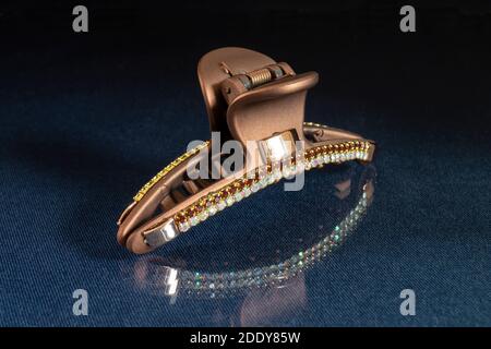The Hair clip. The Pin for hair on turn blue the table with reflection. Personal subjects on black background Stock Photo