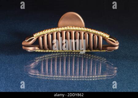 The Hair clip. The Pin for hair on turn blue the table with reflection. Personal subjects on black background Stock Photo