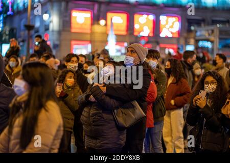 Crowds of people wearing masks gather at Puerta del Sol, Madrid's central square, waiting for the City Council to turn on the Christmas lights.Madrid officially starts the Christmas season by turning on 10.8 million LED lights throughout the capital. In total, there are more than 210 illuminated streets distributed throughout the 21 districts of the city of Madrid. The Community of Madrid proposed to the Spanish Ministry of Health a plan for Christmas, in which family and social gatherings are with a maximum of 10 people from three different groups of partners. Also on December 24, 25, 31 and Stock Photo