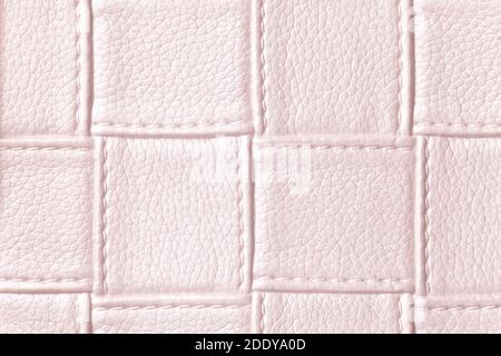 Texture of light pink leather background with square pattern and stitch, macro. Abstract rose backdrop from modern decorative light pearl textile with Stock Photo