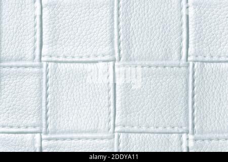 Texture of light blue leather background with square pattern and stitch, macro. Abstract backdrop from modern decorative light sky textile with geomet Stock Photo