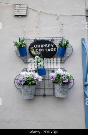 artificial flowers in pots,hanging on house wall, england Stock Photo