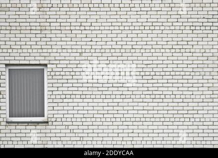 White brick wall with a window opening and a window. Vintage light background for creative design. The old wall. Stock Photo