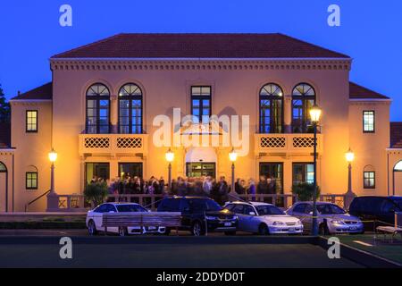 The historic Blue Baths building (1933) in Rotorua, New Zealand, seen at night with a crowd of people outside