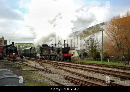 '30053' sits in the goods yard at Corfe Castle as '30120' and 'Manston' double head through the station. Stock Photo